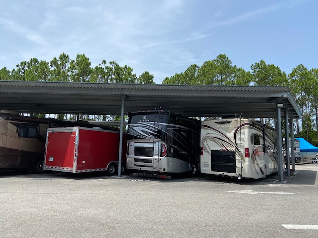 A group of three recreational vehicles parked in a lot.